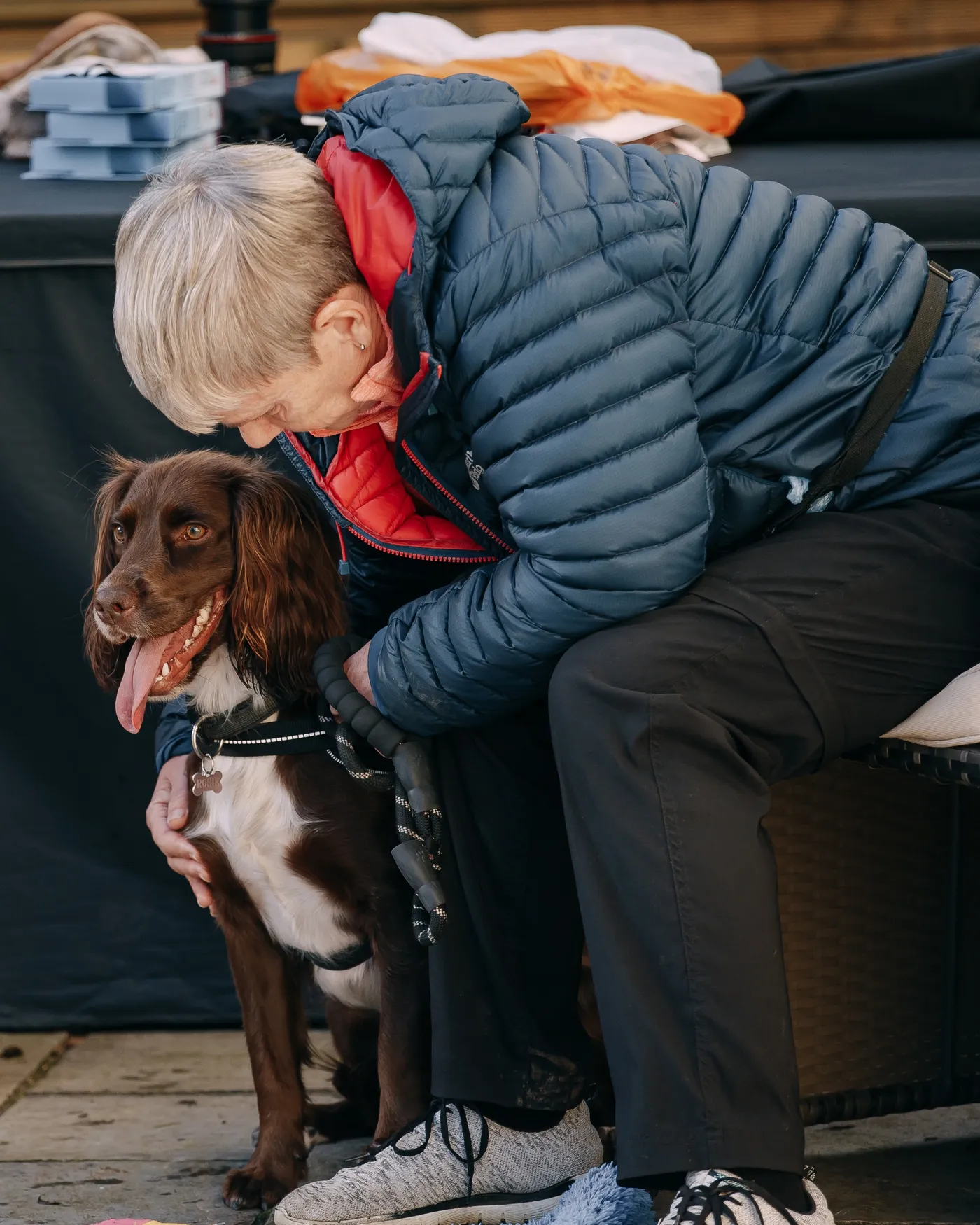 An owner hugging her happy spaniel at a class
